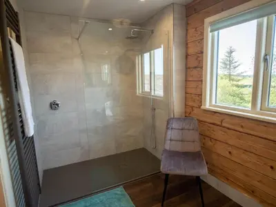 a bathroom with a shower with a chair and a window at Casa Loma in Carnforth