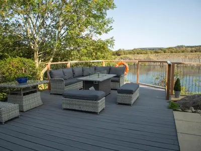 a deck with a couch and a table and chairs at Casa Loma in Carnforth