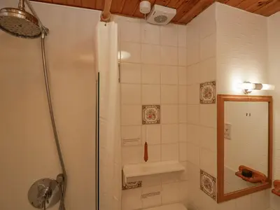 a shower with a glass door in a bathroom at Lazey Cottage in Millom