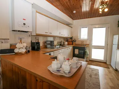 a kitchen with a wooden counter top with dishes on it at Lazey Cottage in Millom