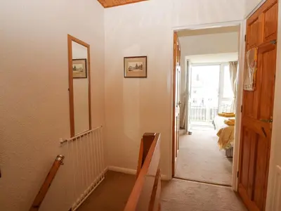 a hallway with a door leading to a bedroom at Lazey Cottage in Millom
