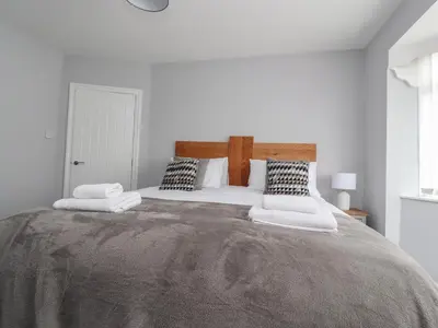 a bedroom with a large bed with two pillows at 23 Ryden Avenue in Cleveleys