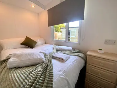 a bedroom with a bed with towels on it at Elletson Park Wood fired Hot tubs, Caravans & Pods in Preston