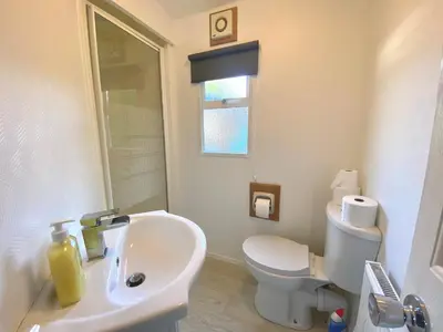 a bathroom with a white sink and a toilet at Elletson Park Wood fired Hot tubs, Caravans & Pods in Preston