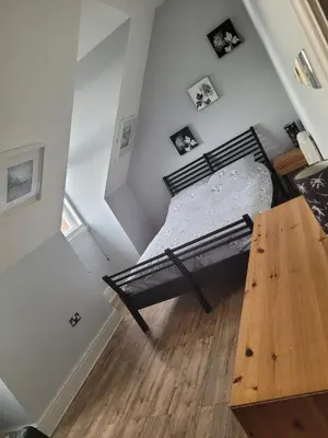 a bedroom with a bed and a wooden table at Marina Court LA14 2HL in Barrow in Furness
