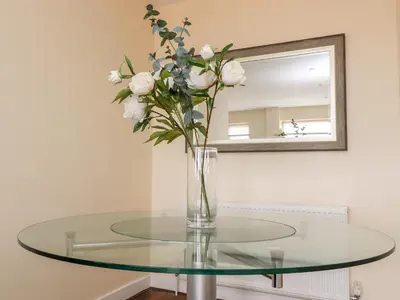 a glass table with a vase of flowers on it at The Beach House in Cleveleys