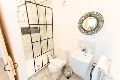 a bathroom with a shower and a toilet and a sink at Milo’s Retreat in Arnside