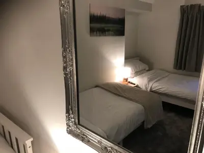 a mirror in a room with two beds and a lamp at North Lodge in Lancaster