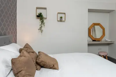 a bedroom with a white bed with pillows on it at North Lodge in Lancaster
