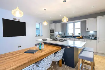 a kitchen with a large island with a wooden counter top at North Lodge in Lancaster