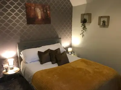 a bedroom with a bed and two tables with lamps at North Lodge in Lancaster