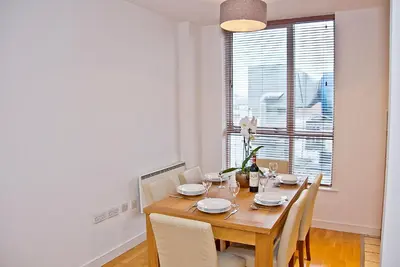 a dining room with a table and chairs and a window at Base Serviced Apartments - Duke Street in Liverpool