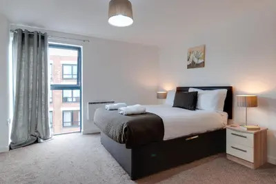 a bedroom with a bed and a large window at Base Serviced Apartments - Duke Street in Liverpool