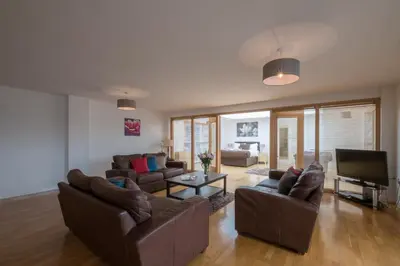 a living room with couches and a flat screen tv at Base Serviced Apartments - Duke Street in Liverpool