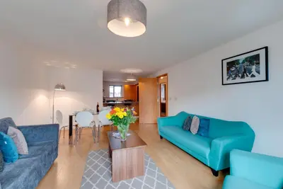 a living room with two blue couches and a table at Base Serviced Apartments - Duke Street in Liverpool