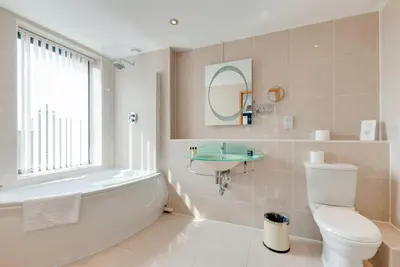 a bathroom with a tub and a toilet and a sink at Base Serviced Apartments - Duke Street in Liverpool