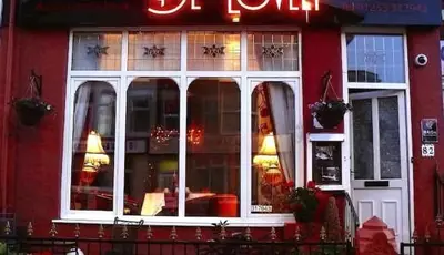 a red building with a large window of a restaurant at Delovely Hotel in Blackpool