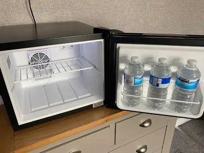an open refrigerator with bottles of water in it at Delovely Hotel in Blackpool