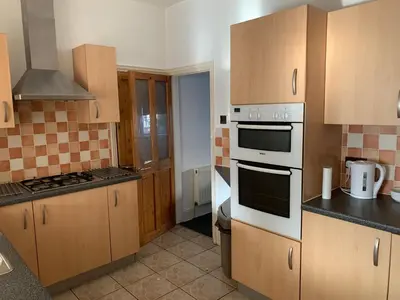 a kitchen with white appliances and wooden cabinets at Beautiful house in a perfect location in Saint Annes on the Sea