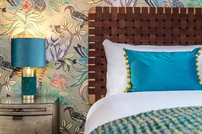 a bed with a blue pillow and a lamp on a table at Host & Stay - The Pilgrim Coach Houses in Liverpool