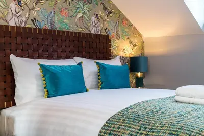 a bedroom with a large bed with blue pillows at Host & Stay - The Pilgrim Coach Houses in Liverpool