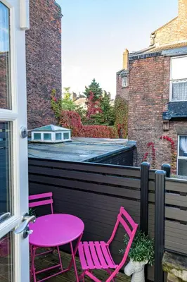 two pink chairs and a pink table on a balcony at Host & Stay - The Pilgrim Coach Houses in Liverpool