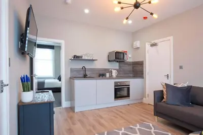a living room with a couch and a kitchen at BlackBird Luxury Accommodation Room 6 in Blackpool