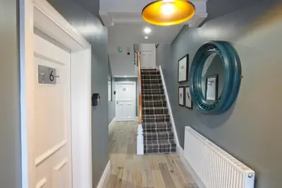 a hallway with a blue mirror and stairs at BlackBird Luxury Accommodation Room 6 in Blackpool