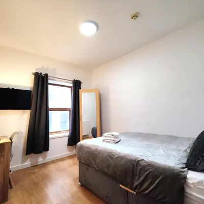 a bedroom with a large bed and a window at Liverpool City Centre Private Rooms including smart TVs - with Shared Bathroom in Liverpool