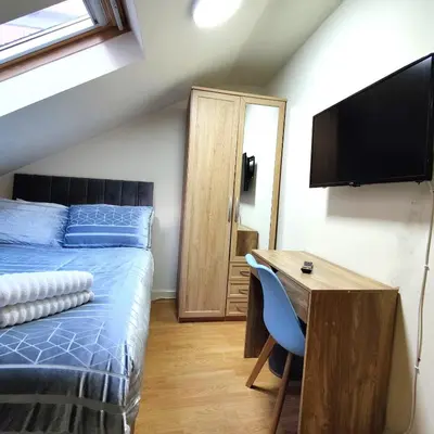 a bedroom with a bed and a desk and a television at Liverpool City Centre Private Rooms including smart TVs - with Shared Bathroom in Liverpool