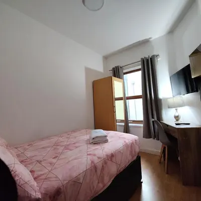 a bedroom with a bed and a desk and a window at Liverpool City Centre Private Rooms including smart TVs - with Shared Bathroom in Liverpool