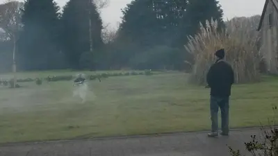 a man standing in a field looking at a helicopter at Harris End in Lancaster