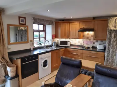 a kitchen with wooden cabinets and a sink and a dishwasher at Harris End in Lancaster