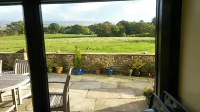 a window view of a patio with a table and chairs at Harris End in Lancaster