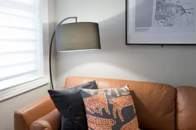 a lamp sitting next to a brown leather couch at Blackbird Luxury 2 Bed Accommodation Room 7 in Blackpool