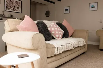 a couch with pillows on it in a living room at Cottage - Sleeps4 - PetFriendly - Garden - ByBeach in Saint Annes on the Sea