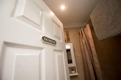 a door with a exit sign on it in a bathroom at Cottage - Sleeps4 - PetFriendly - Garden - ByBeach in Saint Annes on the Sea