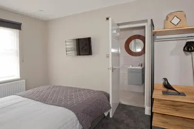 a bedroom with a bed and a bathroom with a mirror at Blackbird Luxury 2 Bed Accomodation Room 8 in Blackpool