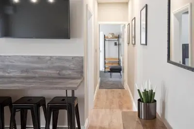 a dining room with a wooden table and stools at Blackbird Luxury 2 Bed Accomodation Room 8 in Blackpool