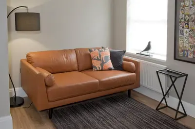 a brown leather couch in a living room with a window at Blackbird Luxury 2 Bed Accomodation Room 8 in Blackpool