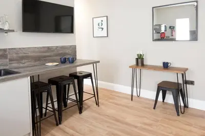 a kitchen with two tables and stools and a counter at Blackbird Luxury 2 Bed Accomodation Room 8 in Blackpool