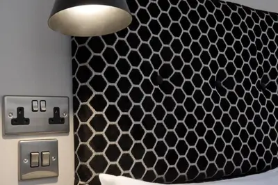 a black and white wall with a light and an electrical socket at Blackbird Luxury 2 Bed Accomodation Room 8 in Blackpool