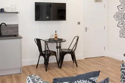 a dining room table with two chairs and a television at Blackbird Luxury Accommodation Studio Room 9 in Blackpool