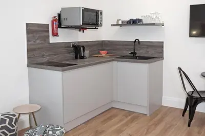 a kitchen with white cabinets and a sink at Blackbird Luxury Accommodation Studio Room 9 in Blackpool