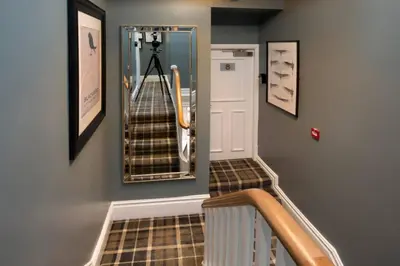 a hallway with a staircase with a mirror on the wall at Blackbird Luxury Accommodation Room 10 in Blackpool