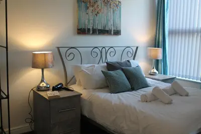 a bedroom with a white bed with pillows and two lamps at The Myriad in Preston
