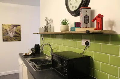 a kitchen with a sink and a clock on the wall at The Myriad in Preston