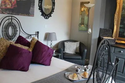 a bedroom with a bed with purple pillows and a chair at The Myriad in Preston