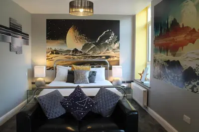 a bedroom with a bed and a couch with pillows at The Myriad in Preston