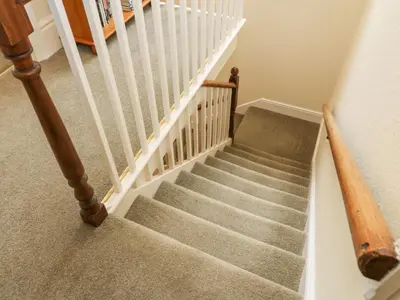 a staircase with white railings and a stair case at Westmorland Cottage in Grange Over Sands